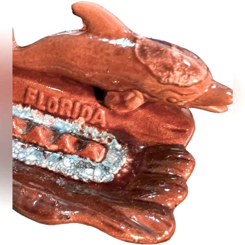 Vintage Ceramic Florida Ashtray with a Brown Dolphin Swimming in Blue Water.